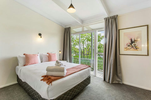 Queen bedroom with access to the outside deck area through sliding doors.