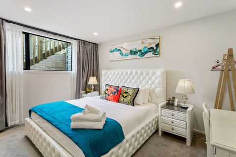 Main bedroom has a king sized bed, quilted headboard and matching side tables.