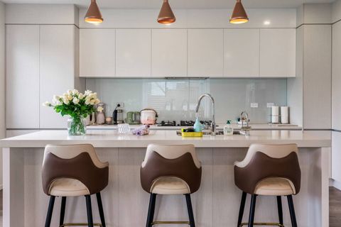 White minimalist kitchen with plenty of storage, double sink and gas burners.