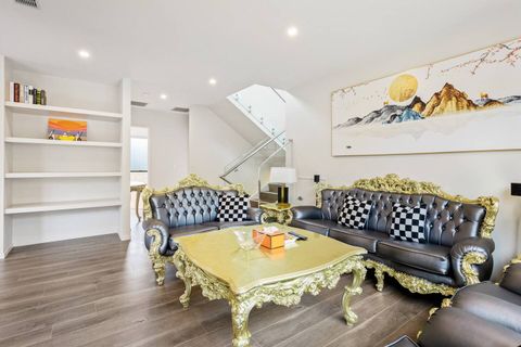 Bookcase, artwork and the stairs down from the foyer. Comfortable lounge chairs.