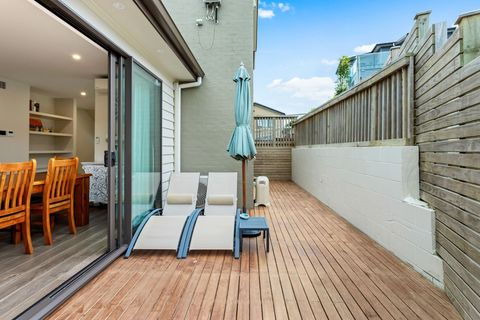 Deck by dining area with sun loungers and umbrella.