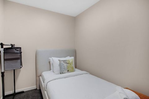 The other single room has a clothing rack for storage.