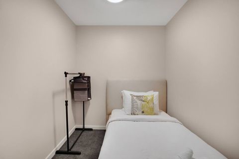 This bedroom is located off the main living space and has a glass window that lets in the light.