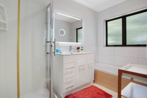 The bathroom has a shower, bath-tub and vanity unit.