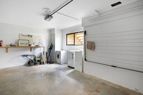 The washing machine and dryer are in the garage with a clothes line that can be erected and a drying rack.