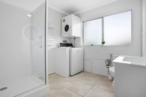 The bathroom features a spacious shower, toilet and vanity unit.
