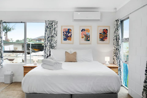 The Super-King bed is inviting with its crisp white sheets and colourful artwork on the wall.