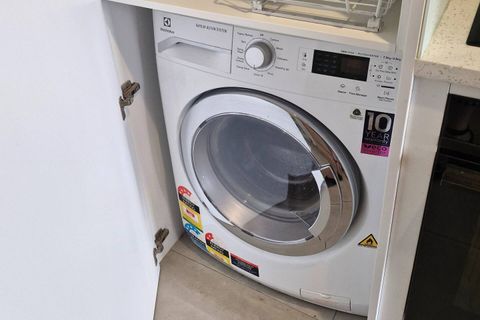 The washer/dryer combo is in the cupboard beside the kitchen.