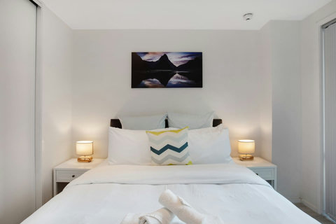 The Queen bed looks cosy and inviting with its bedside tables and soft lighting.