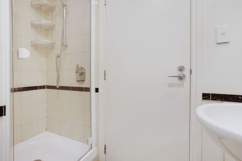 The shower is behind the door in the bathroom.