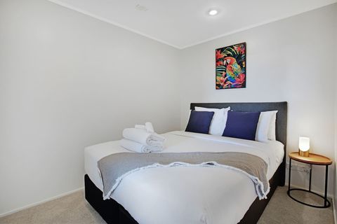 With blue cushions and a grey throw, this bed invites you to sleep under the crisp white sheets.