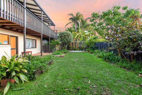The backyard has lovely gardens and trees to enjoy.