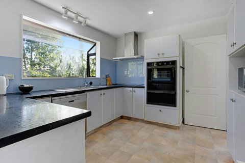 The kitchen has a oven, cooktop, microwave and dishwasher.