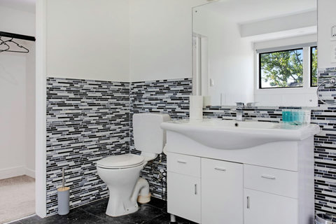 The ensuite bathroom is spacious with a toilet, and large vanity unit.