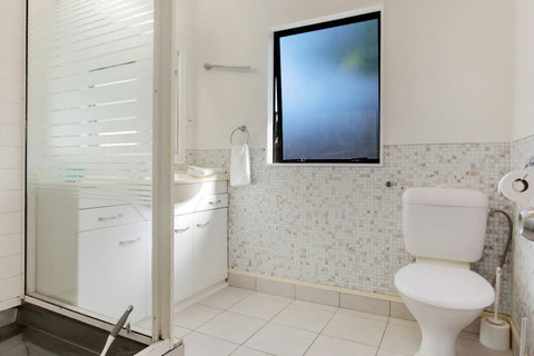 The family bathroom has a shower, vanity and toilet.