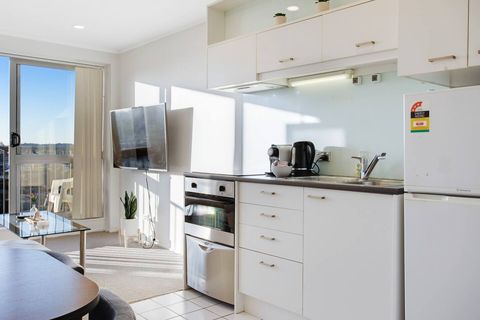 The kitchen has an oven, dishwasher, cooktop, microwave, and fridge/freezer.