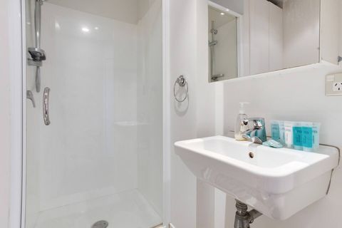 The bathroom has a shower, vanity unit and toilet.