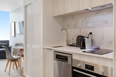 The kitchen has a cooktop, oven, dishwasher, microwave and fridge/freezer.