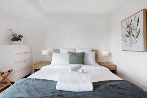 With matching blue throw and cushions, this bed invites you to rest under the crisp white sheets.