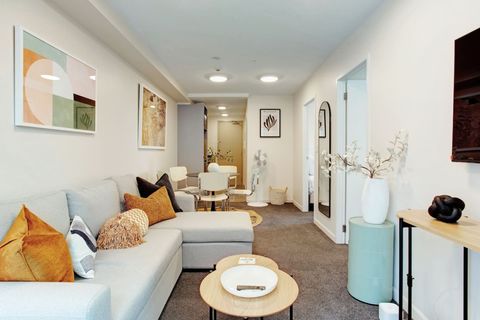 The open-plan living, dining and kitchen areas are filled with light from the windows.