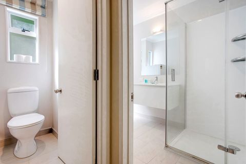 The toilet is next door to the bathroom but in a separate room.