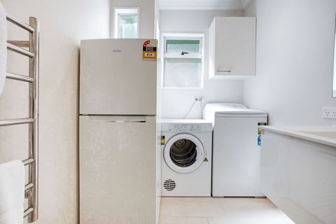 The washing machine, dryer and fridge/freezer are all in the bathroom area.