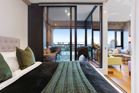 This bedroom has sliding doors that open onto the living spaces and balcony.