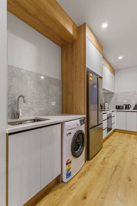 The washing machine is located in the kitchen area.