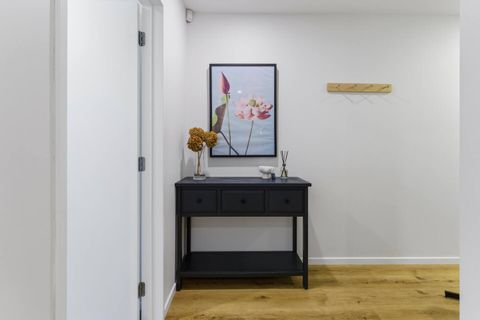 The hallway showcases wooden floors and a hall console.