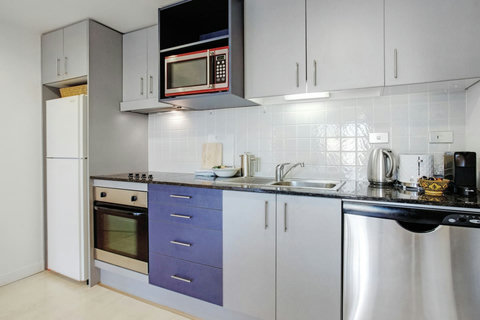 The kitchen has an oven, cooktop, microwave, dishwasher and fridge/freezer