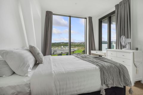 The bedroom is well-lit with floor-to-ceiling windows.