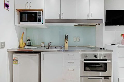 The kitchen has an oven, cooktop, mini fridge, microwave and dishwasher.