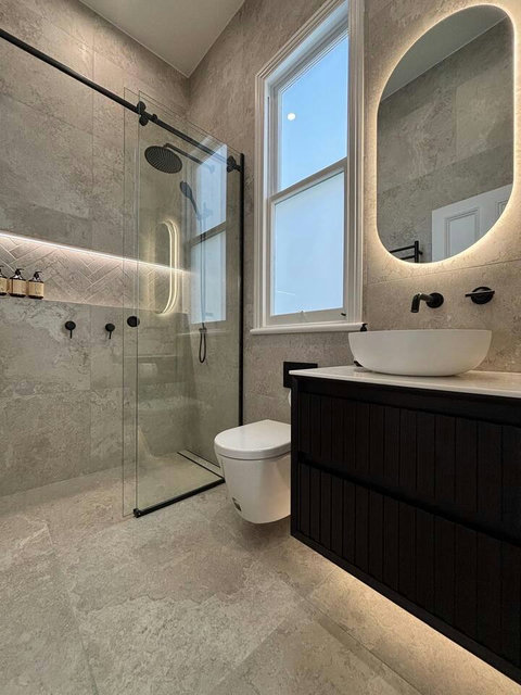 The bathroom is modern with tiling throughout and updated fixtures.
