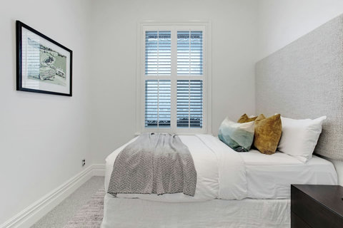 With a grey throw and mustard cushions, this bed invites you to rest under the crisp white sheets.