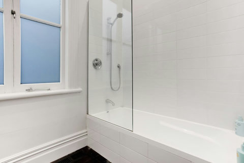 This family bathroom has a shower over bath, basin and toilet.