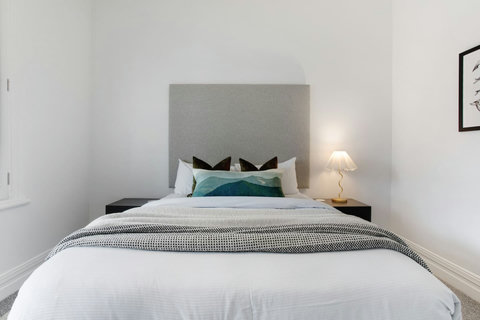 The Queen bed has pops of colour with the artwork and cushions.