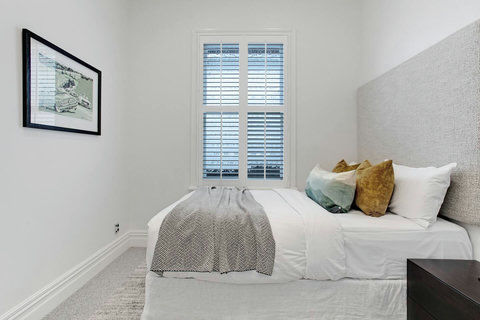 With a grey throw and mustard cushions, this bed invites you to rest under the crisp white sheets.