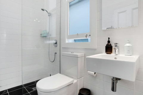 The ensuite bathroom has a shower, toilet, heated towel rail and vanity unit.
