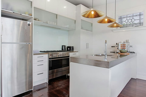 The kitchen is well-equipped with a coffee machine, dishwasher, microwave, gas cooktop, oven, and fridge/freezer.