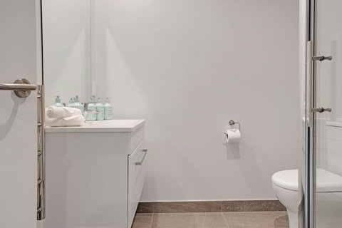 The bathroom has a toilet, shower and vanity unit.