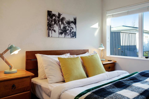 The double bed is cosy and inviting with a checkered throw.