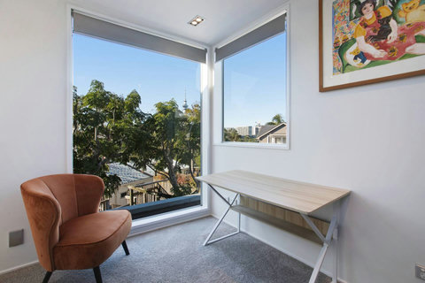 The office desk is located in the hallway area on the upstairs floor.