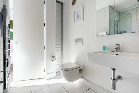 There is a vanity, glass shower and toilet in the shared bathroom.