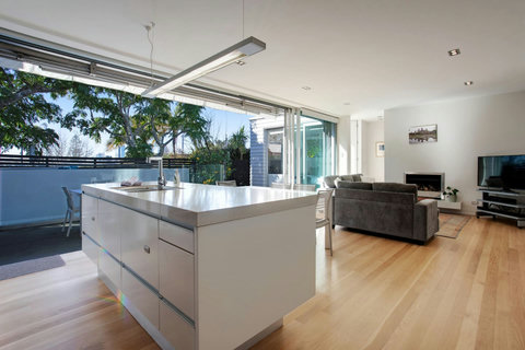 The sleek marble countertop kitchen island is perfectly positioned to interact with the rest of the family.