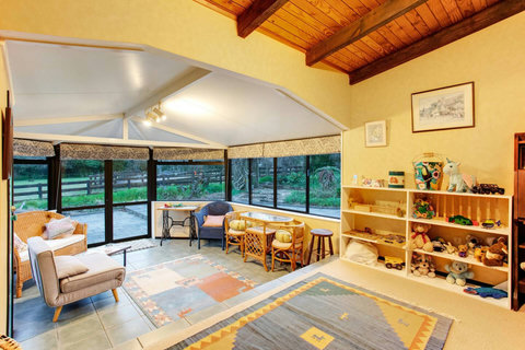The conservatory is a second living room space that has plenty of seating and toys for the children to play with.