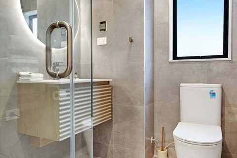 The ensuite bathroom has a toilet, vanity, shower and back-lighted mirror.
