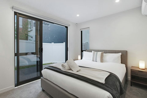 The ground floor bedroom has a ranch slider to open and step-out to the balcony/grass area.