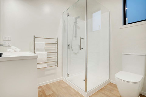 The ensuite bathroom has a shower, toilet, heated towel rail and vanity.