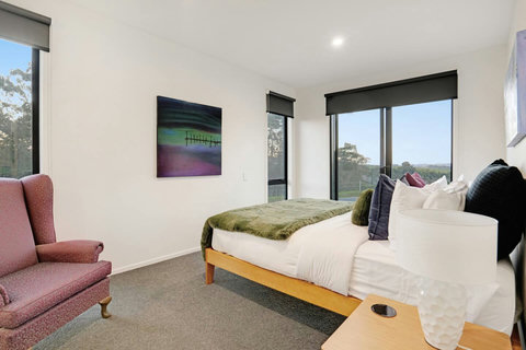 The artwork provides the pallet for the room of purple, green and blue.