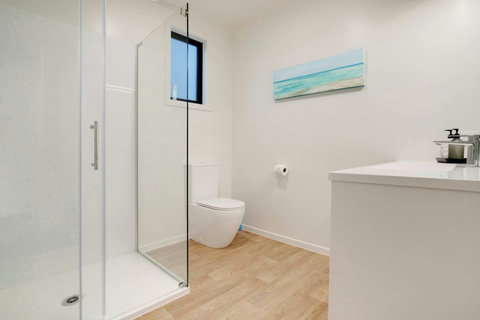 The modern bathroom is clean and spacious with neutral fittings.